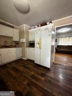 1581 Farmington Rd, Madison, GA 30650 - kitchen with white refrigerator with ice dispenser, stainless steel microwave, white cabinets, dark countertops, and dark wood-style flooring
