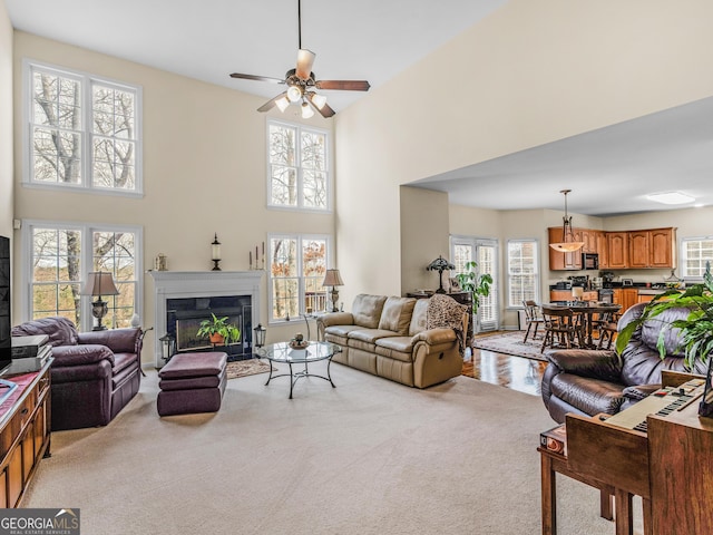 17 Rocky Mountain Pass, Adairsville, GA 30103 - living area with light colored carpet, healthy amount of natural light, a ceiling fan, a fireplace with flush hearth, and a high ceiling