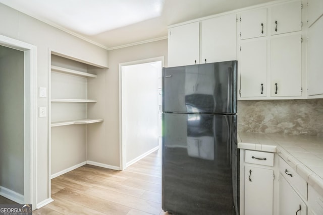 6770 Burkhead Dr, Union City, GA 30291 - kitchen featuring freestanding refrigerator, tile counters, light wood-style flooring, ornamental molding, and decorative backsplash