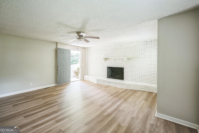 6770 Burkhead Dr, Union City, GA 30291 - unfurnished living room featuring a ceiling fan, a textured ceiling, wood finished floors, and a fireplace