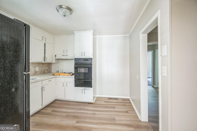 6770 Burkhead Dr, Union City, GA 30291 - kitchen featuring black appliances, under cabinet range hood, a warming drawer, light countertops, and light wood-style floors