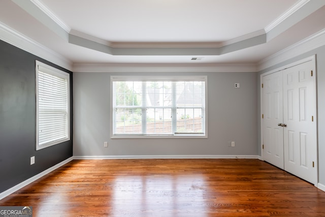 4311 Hampton Mill Pkwy, Douglasville, GA 30135 - unfurnished bedroom featuring a raised ceiling, crown molding, wood finished floors, and a closet