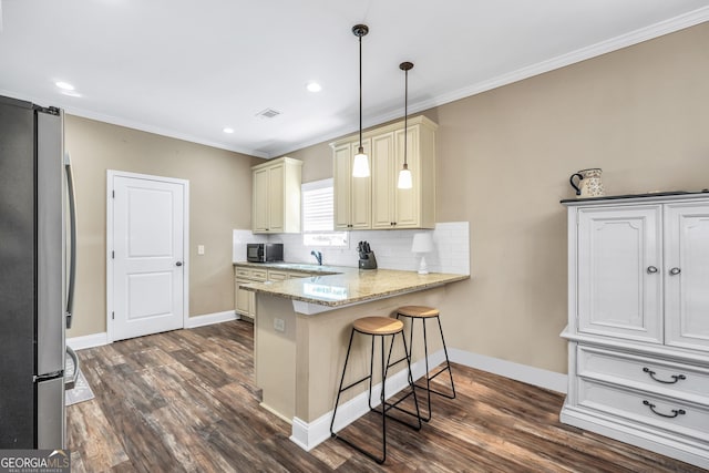 230 Thorpe Rd, Jackson, GA 30233 - kitchen featuring freestanding refrigerator, cream cabinets, a peninsula, dark wood-type flooring, and ornamental molding