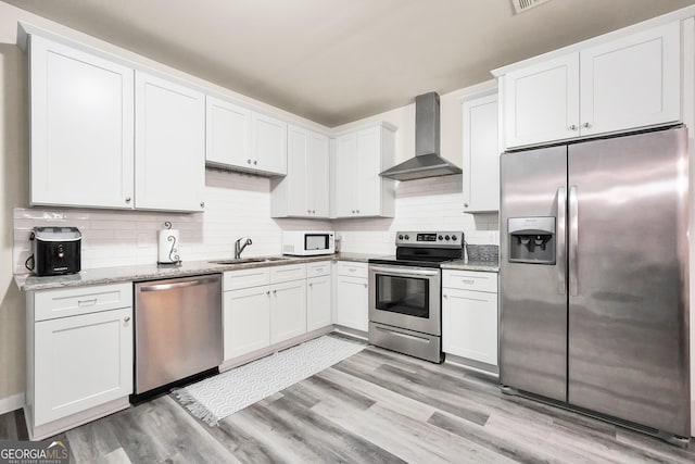 230 Thorpe Rd, Jackson, GA 30233 - kitchen with stainless steel appliances, wall chimney range hood, white cabinets, light wood-type flooring, and backsplash