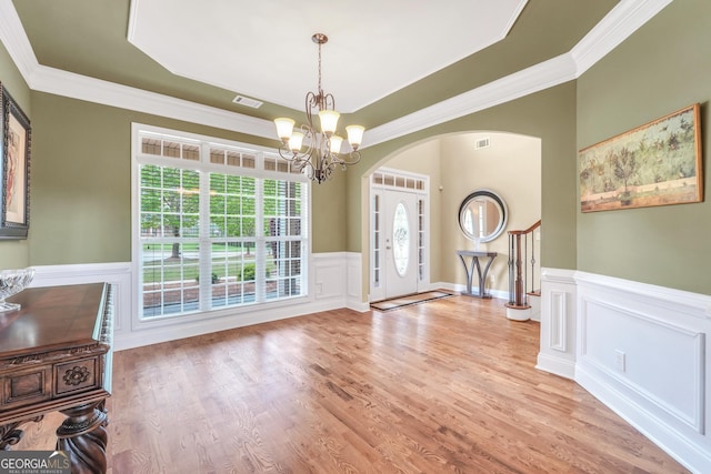 204 Carmell Ct, Mcdonough, GA 30252 - entryway with arched walkways, a chandelier, wainscoting, crown molding, and wood finished floors