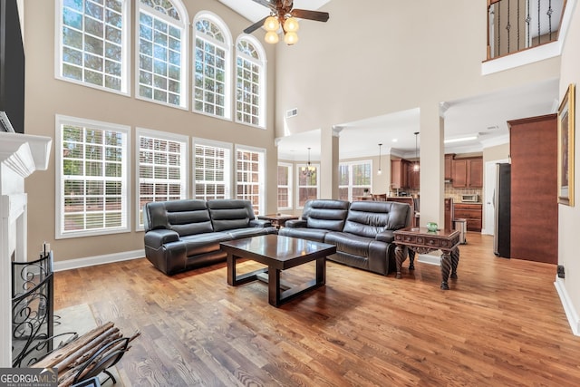 204 Carmell Ct, Mcdonough, GA 30252 - living area with a towering ceiling, a fireplace, light wood-type flooring, and a ceiling fan