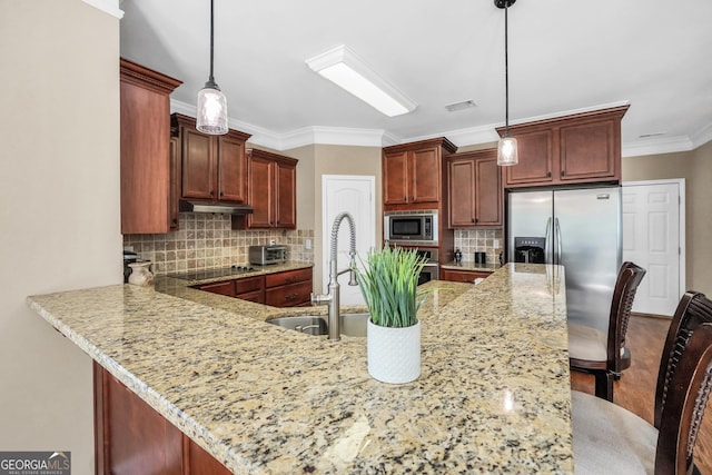 204 Carmell Ct, Mcdonough, GA 30252 - kitchen featuring stainless steel appliances, a peninsula, backsplash, under cabinet range hood, and hanging light fixtures