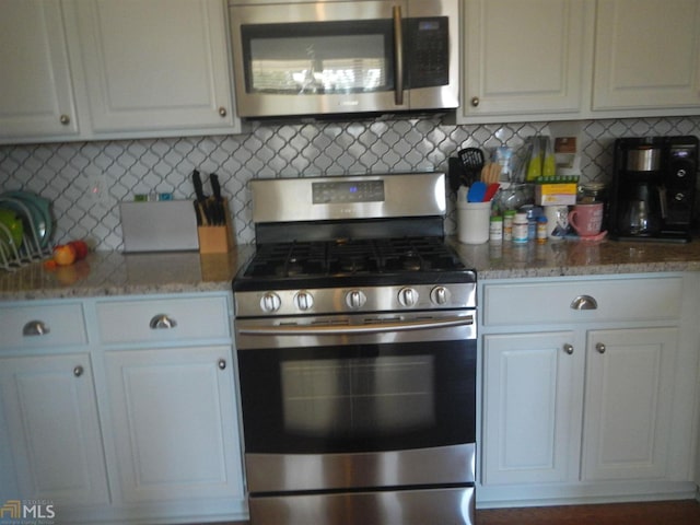 3607 Wood Point Way, Gainesville, GA 30507 - kitchen with stainless steel appliances, white cabinets, light stone counters, and backsplash