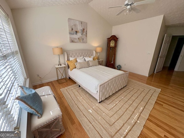 3076 Harris Mill Ct, Duluth, GA 30096 - bedroom featuring wood finished floors, vaulted ceiling, a textured ceiling, and ceiling fan