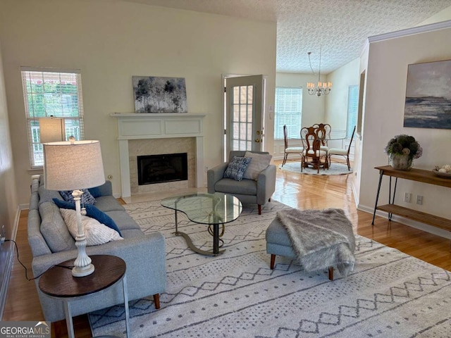3076 Harris Mill Ct, Duluth, GA 30096 - living area with lofted ceiling, healthy amount of natural light, a chandelier, wood finished floors, and a textured ceiling