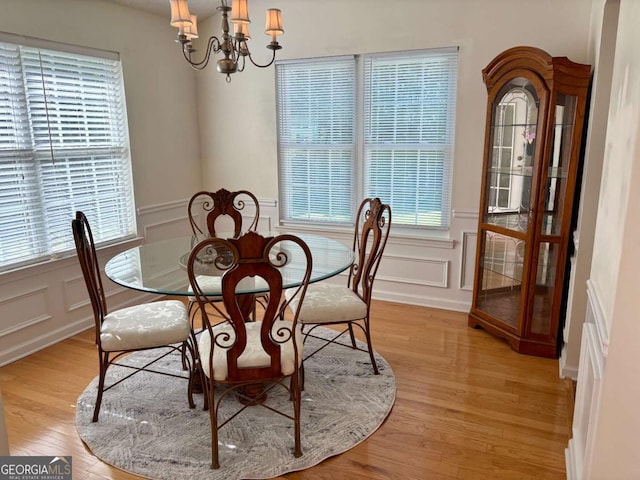 3076 Harris Mill Ct, Duluth, GA 30096 - dining room featuring a decorative wall, a chandelier, light wood-type flooring, and a wainscoted wall