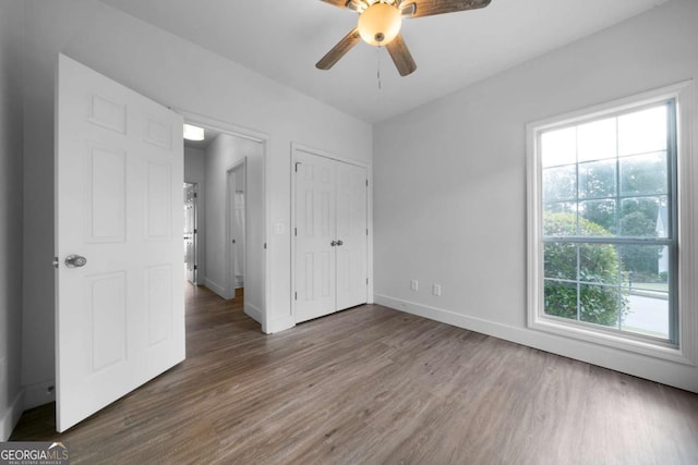 3047 Standing Rock Ct, Lithia Springs, GA 30122 - unfurnished bedroom featuring wood finished floors, multiple windows, a closet, and ceiling fan
