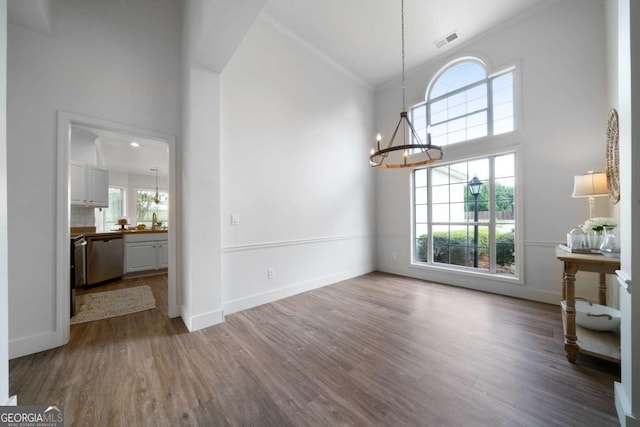 3047 Standing Rock Ct, Lithia Springs, GA 30122 - unfurnished dining area featuring a chandelier, healthy amount of natural light, wood finished floors, and a high ceiling