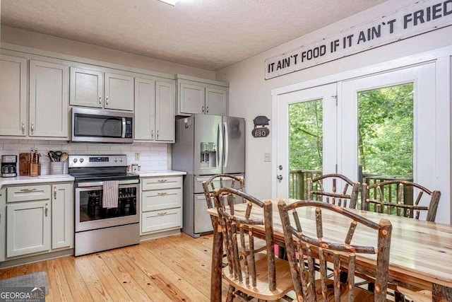 104 Buck Run E, Dahlonega, GA 30533 - kitchen with stainless steel appliances, backsplash, light countertops, light wood-type flooring, and gray cabinetry