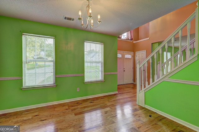 1067 Misty Meadows Pt, Hampton, GA 30228 - entrance foyer featuring a chandelier, stairway, wood finished floors, and a textured ceiling