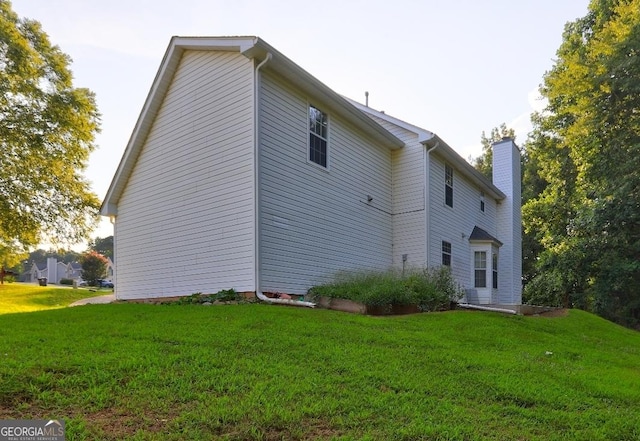1067 Misty Meadows Pt, Hampton, GA 30228 - rear view of house with a chimney and a lawn