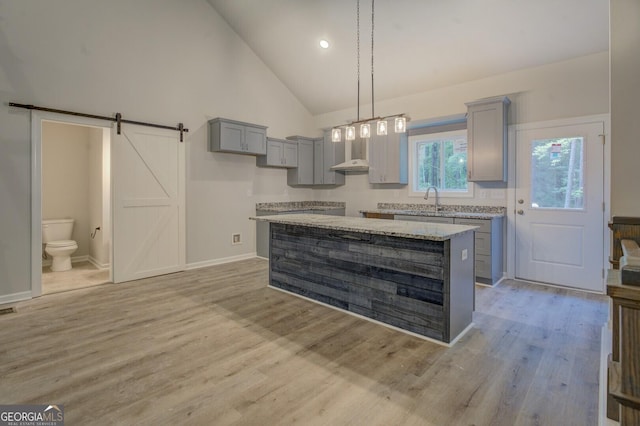 48 Bluejay Ct, Monticello, GA 31064 - kitchen with gray cabinetry, light wood-style floors, high vaulted ceiling, hanging light fixtures, and a kitchen island