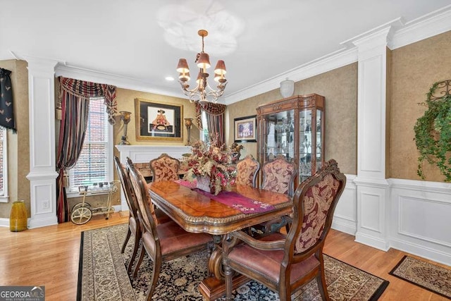 2002 Ivy Ridge Rd SE, Smyrna, GA 30080 - dining room with ornate columns, a chandelier, wood finished floors, ornamental molding, and wallpapered walls