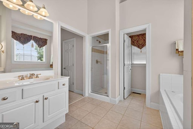 2002 Ivy Ridge Rd SE, Smyrna, GA 30080 - bathroom featuring vanity, a shower stall, tile patterned flooring, a garden tub, and a chandelier