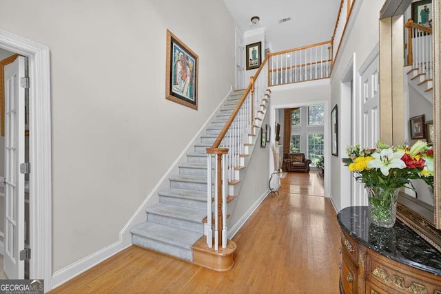 2002 Ivy Ridge Rd SE, Smyrna, GA 30080 - entrance foyer featuring stairs, light wood-style flooring, and a high ceiling