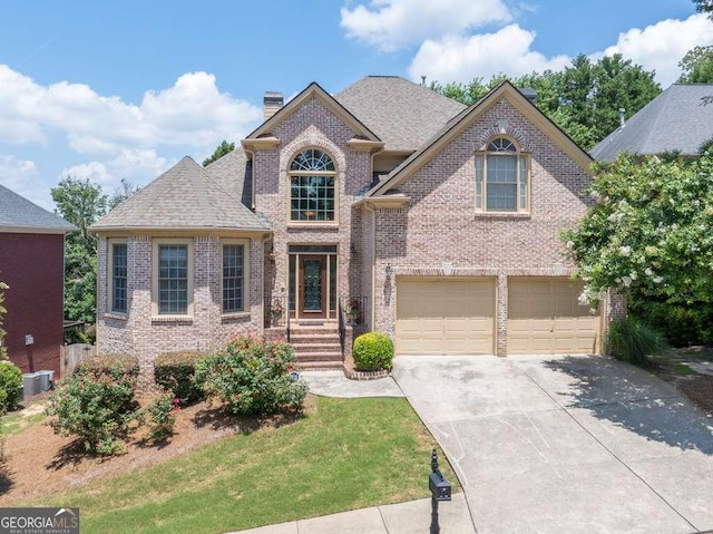 2002 Ivy Ridge Rd SE, Smyrna, GA 30080 - view of front facade with an attached garage, concrete driveway, brick siding, a chimney, and a shingled roof