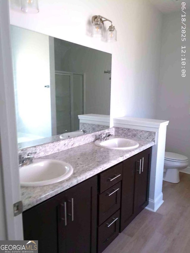 299 Mcclelland Loop NE, Ludowici, GA 31316 - full bathroom featuring wood finished floors, double vanity, and a shower stall