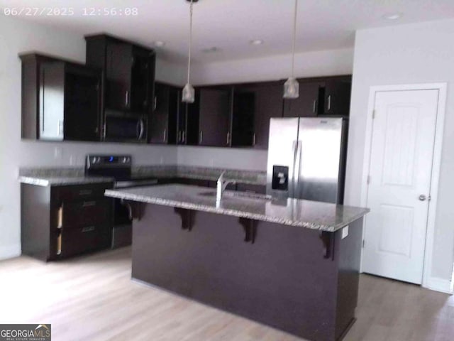 299 Mcclelland Loop NE, Ludowici, GA 31316 - kitchen featuring stainless steel refrigerator with ice dispenser, black range with electric stovetop, a breakfast bar area, and hanging light fixtures