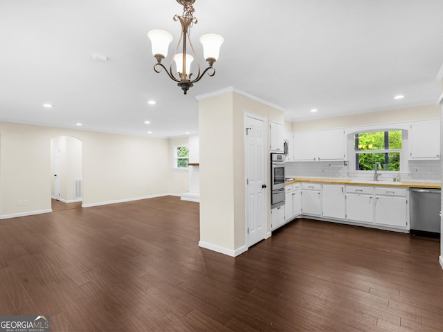 117 Thomas St, Griffin, GA 30224 - kitchen featuring appliances with stainless steel finishes, a warming drawer, light countertops, arched walkways, and tasteful backsplash