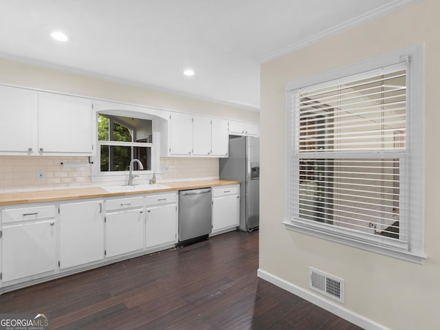 117 Thomas St, Griffin, GA 30224 - kitchen with appliances with stainless steel finishes, decorative backsplash, dark wood finished floors, white cabinets, and light countertops
