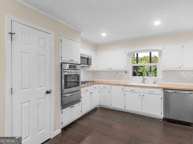 117 Thomas St, Griffin, GA 30224 - kitchen featuring appliances with stainless steel finishes, light countertops, a warming drawer, tasteful backsplash, and crown molding