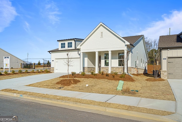 1692 Juniper Berry Way, Loganville, GA 30052 - craftsman inspired home featuring concrete driveway, stone siding, a porch, and a garage
