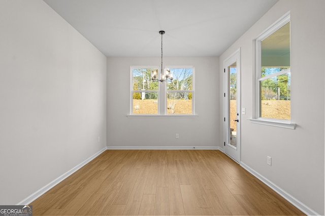 1692 Juniper Berry Way, Loganville, GA 30052 - unfurnished dining area with light wood-style flooring, healthy amount of natural light, and a chandelier