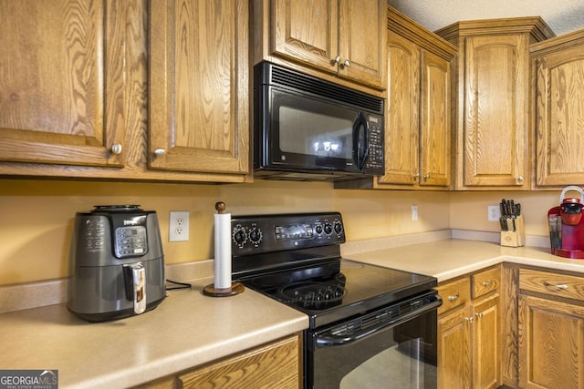 112 Huntwood Ln, Kathleen, GA 31047 - kitchen featuring black appliances, light countertops, and brown cabinets