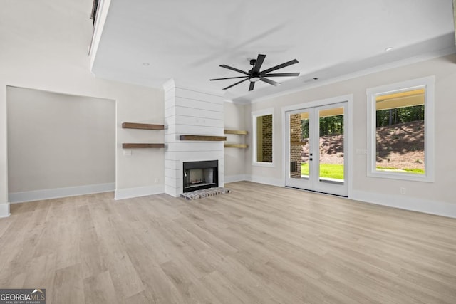 1131 Glen Eagle Dr, Greensboro, GA 30642 - unfurnished living room with ceiling fan, light wood-type flooring, a large fireplace, crown molding, and french doors