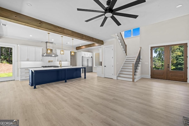 1131 Glen Eagle Dr, Greensboro, GA 30642 - living room featuring french doors, a ceiling fan, stairs, light wood-style floors, and beam ceiling