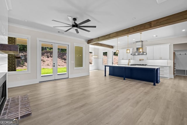 1131 Glen Eagle Dr, Greensboro, GA 30642 - living room featuring ceiling fan, light wood finished floors, a fireplace with raised hearth, recessed lighting, and french doors