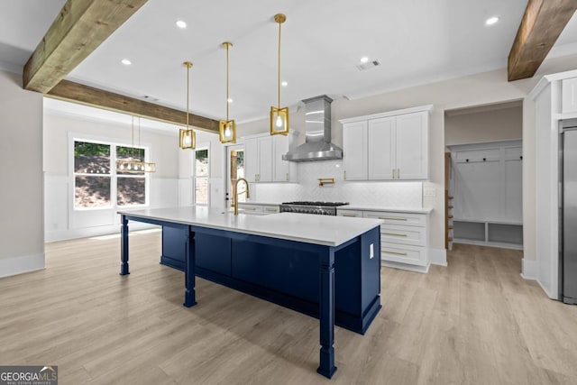 1131 Glen Eagle Dr, Greensboro, GA 30642 - kitchen featuring wall chimney exhaust hood, beamed ceiling, light countertops, a kitchen island with sink, and white cabinetry
