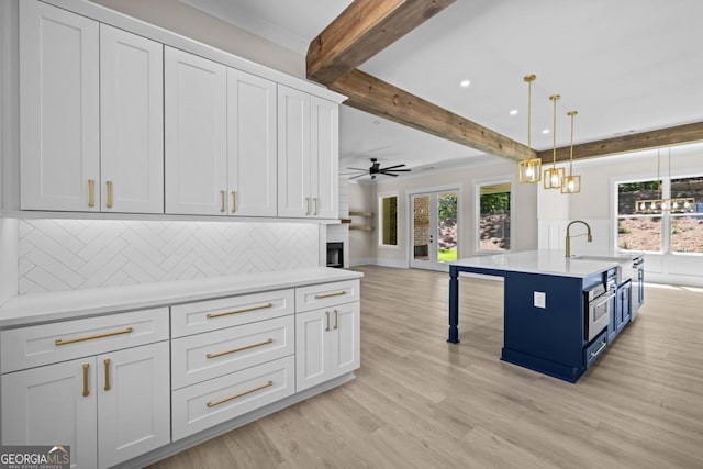 1131 Glen Eagle Dr, Greensboro, GA 30642 - kitchen with beam ceiling, healthy amount of natural light, open floor plan, light wood-type flooring, and light countertops