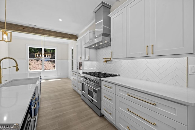 1131 Glen Eagle Dr, Greensboro, GA 30642 - kitchen with range with two ovens, wall chimney range hood, light wood-style floors, white cabinets, and pendant lighting