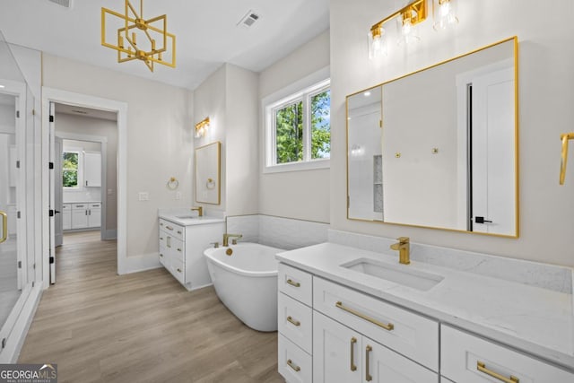 1131 Glen Eagle Dr, Greensboro, GA 30642 - full bathroom featuring two vanities, plenty of natural light, a freestanding bath, and a chandelier