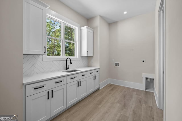 1131 Glen Eagle Dr, Greensboro, GA 30642 - laundry area with cabinet space, electric dryer hookup, light wood-style flooring, and hookup for a washing machine