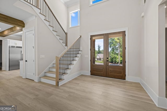 1131 Glen Eagle Dr, Greensboro, GA 30642 - foyer entrance with light wood-type flooring, stairway, french doors, a towering ceiling, and beamed ceiling