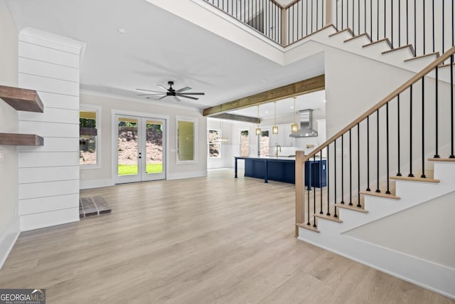 1131 Glen Eagle Dr, Greensboro, GA 30642 - unfurnished living room with french doors, ceiling fan, light wood-style floors, stairway, and a high ceiling