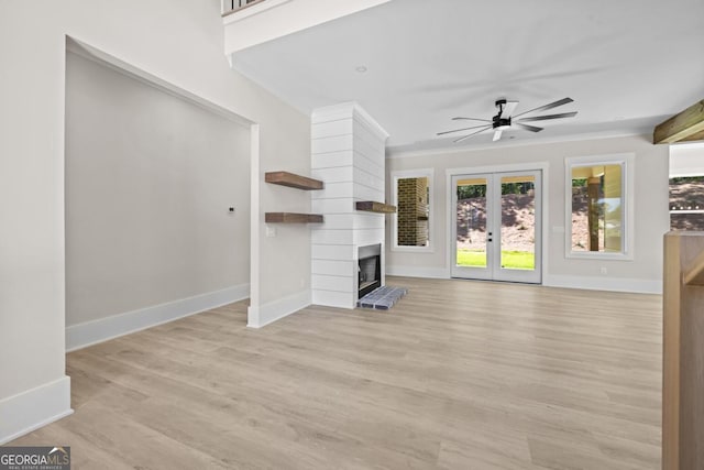1131 Glen Eagle Dr, Greensboro, GA 30642 - unfurnished living room featuring french doors, light wood-style floors, a ceiling fan, and a fireplace