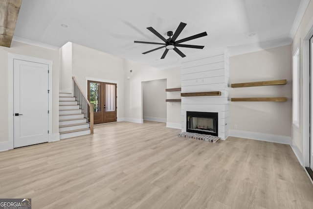 1131 Glen Eagle Dr, Greensboro, GA 30642 - unfurnished living room with light wood-style flooring, a ceiling fan, a fireplace, stairs, and ornamental molding