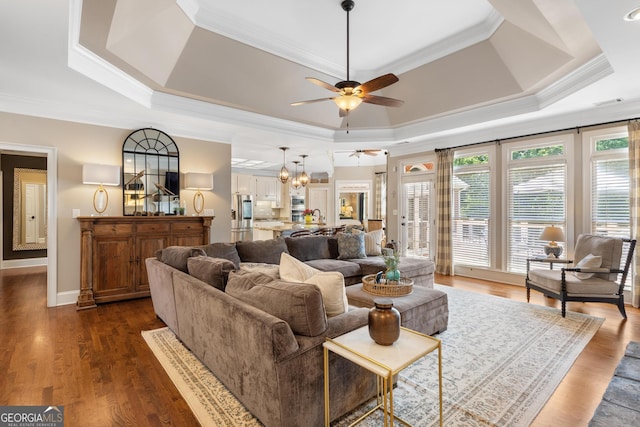 660 Milton Dr, Mcdonough, GA 30252 - living room with ceiling fan, a raised ceiling, crown molding, a chandelier, and dark wood finished floors