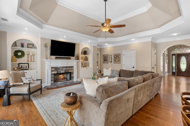 660 Milton Dr, Mcdonough, GA 30252 - living area with a raised ceiling, crown molding, a ceiling fan, built in shelves, and wood finished floors