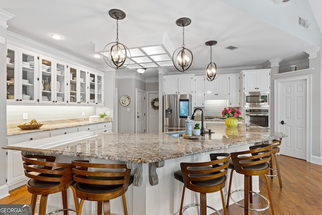 660 Milton Dr, Mcdonough, GA 30252 - kitchen with stainless steel appliances, white cabinets, light wood-type flooring, a chandelier, and backsplash