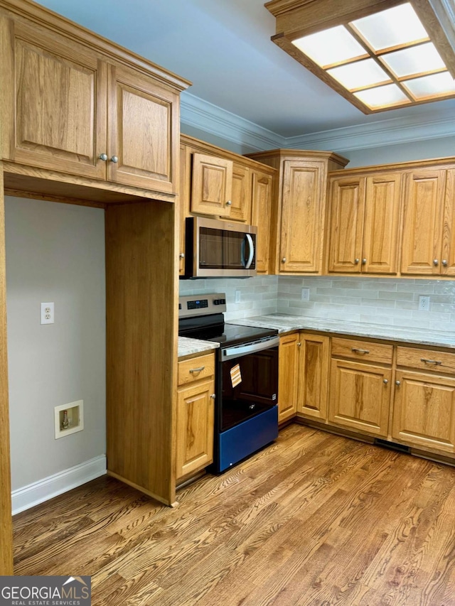 205 Huntington Shoals Dr, Athens, GA 30606 - kitchen with appliances with stainless steel finishes, decorative backsplash, light wood finished floors, and crown molding