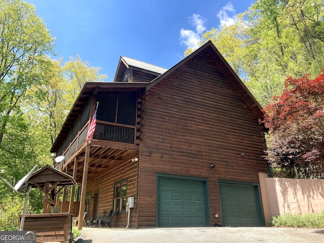 105 Ranch Mountain Ct, Dahlonega, GA 30533 - view of home's exterior featuring a garage, log exterior, a metal roof, and driveway